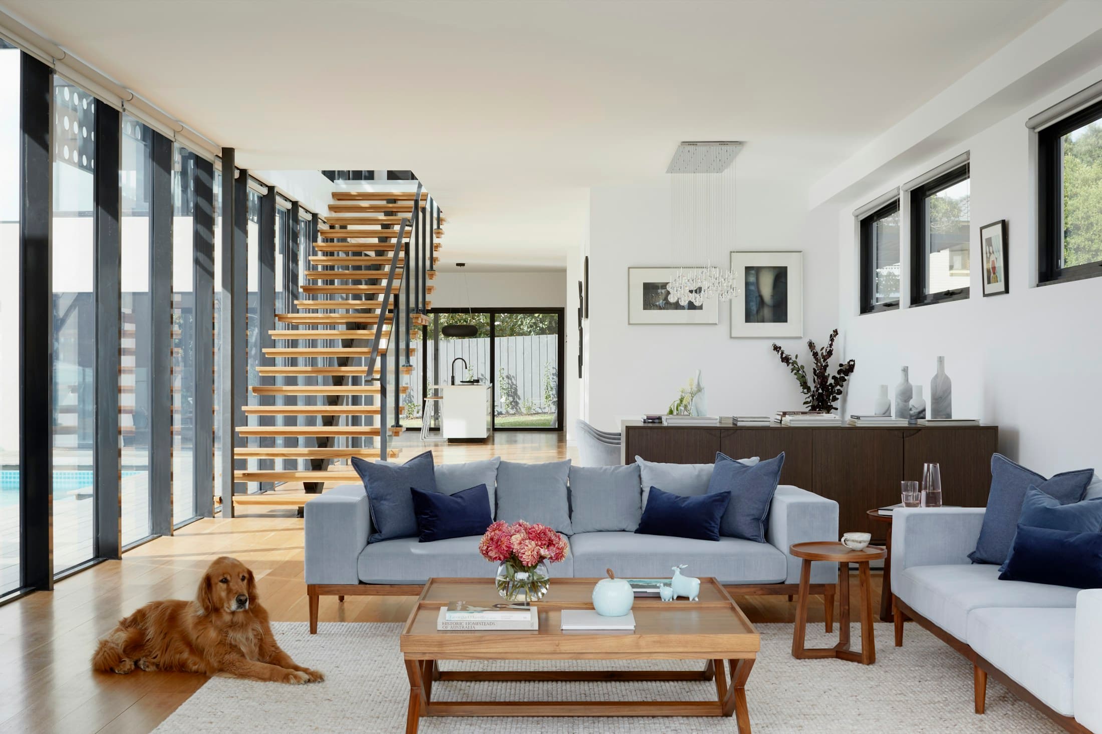 A calm, light-filled living room with comfortable seating and warm wood furnishings
